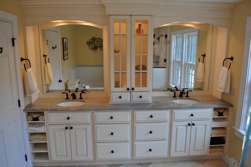 bathroom renovation featuring dual sinks, granite countertop, and built-in storage by BelPort Building & Remodeling in Barnstable, MA