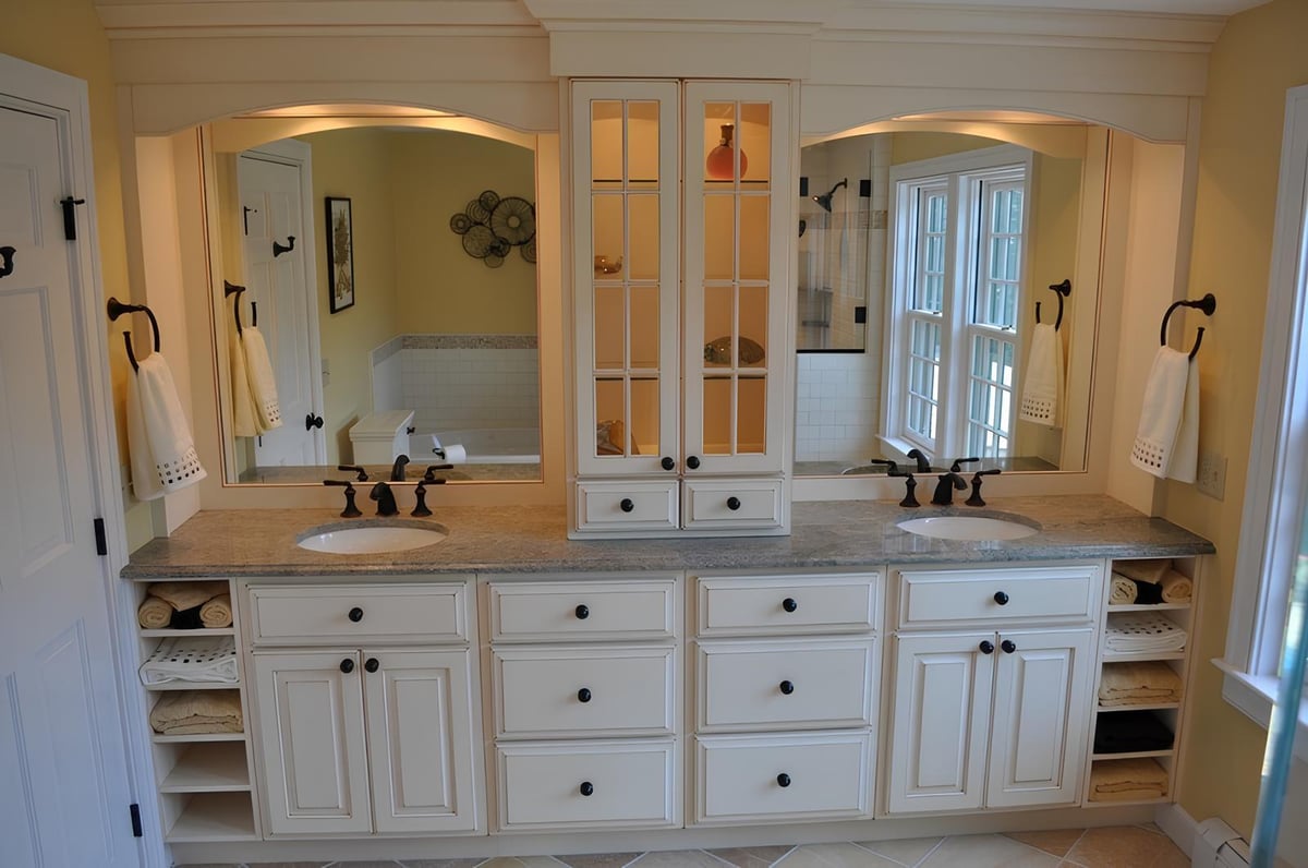 bathroom renovation featuring dual sinks, granite countertop, and built-in storage by BelPort Building & Remodeling in Barnstable, MA