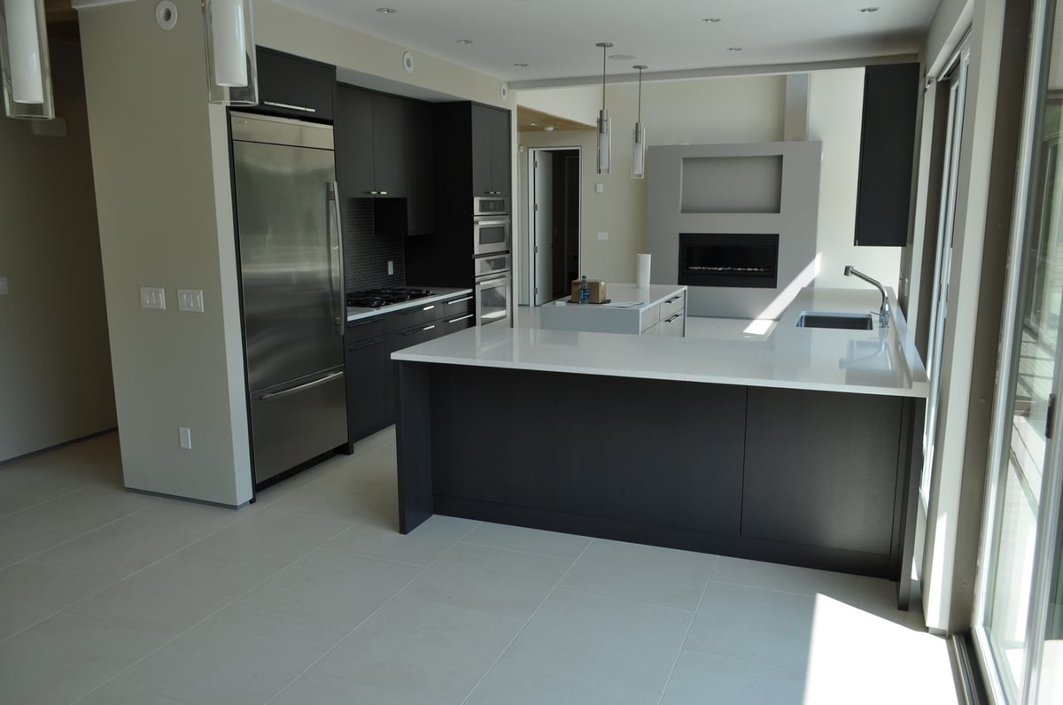 modern kitchen with dark cabinets and island in Mashpee MA custom home by BelPort Building & Remodeling