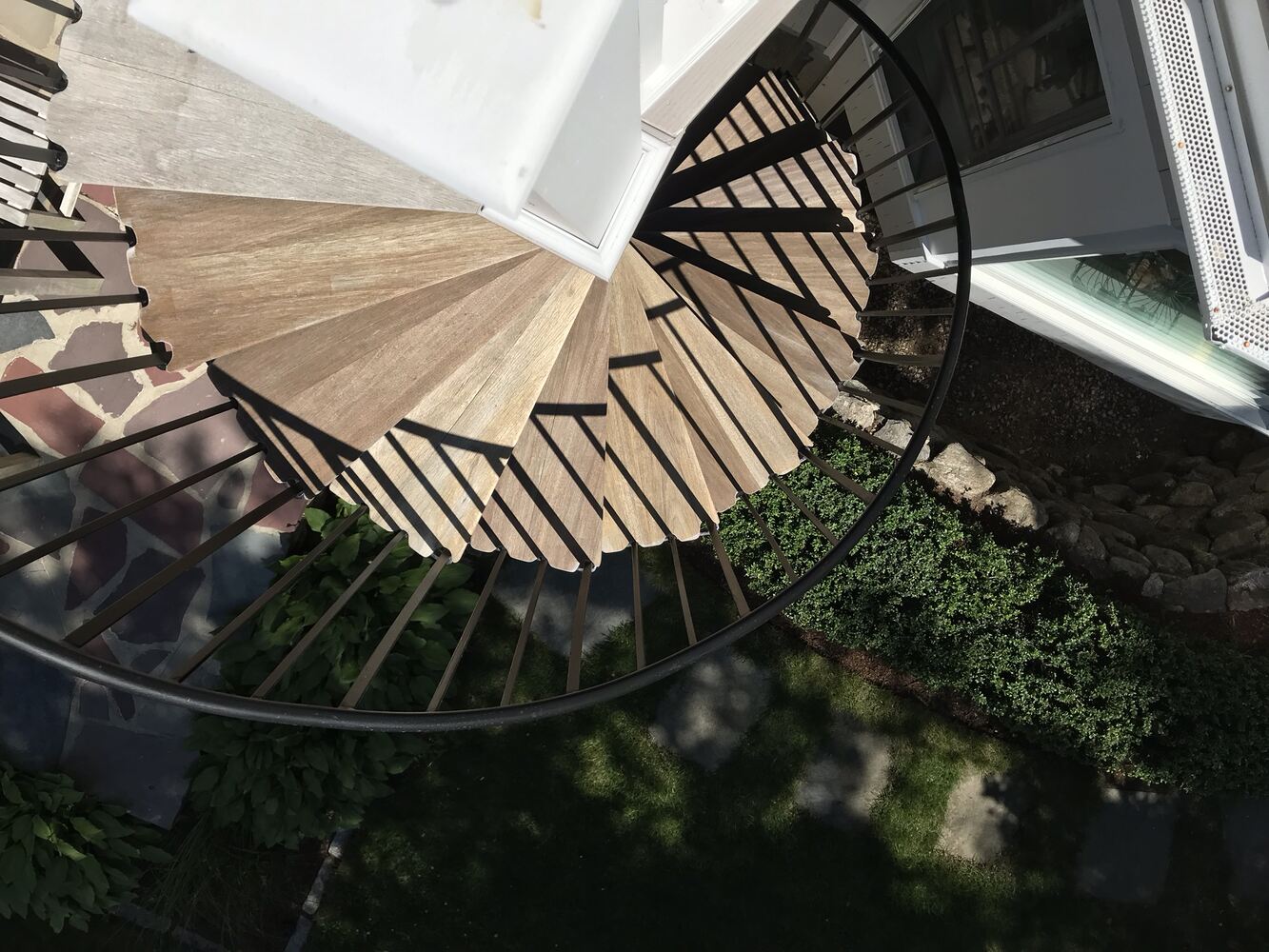 curved exterior staircase with wood treads and metal railing for outdoor living in Barnstable, MA by BelPort Building & Remodeling