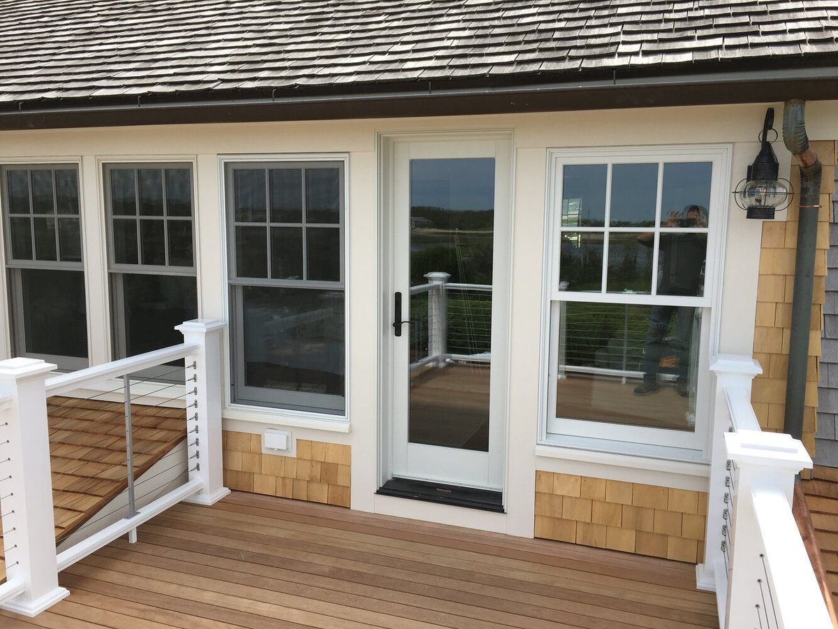 BelPort Building & Remodeling exterior deck with cable railing and door in Barnstable MA remodel