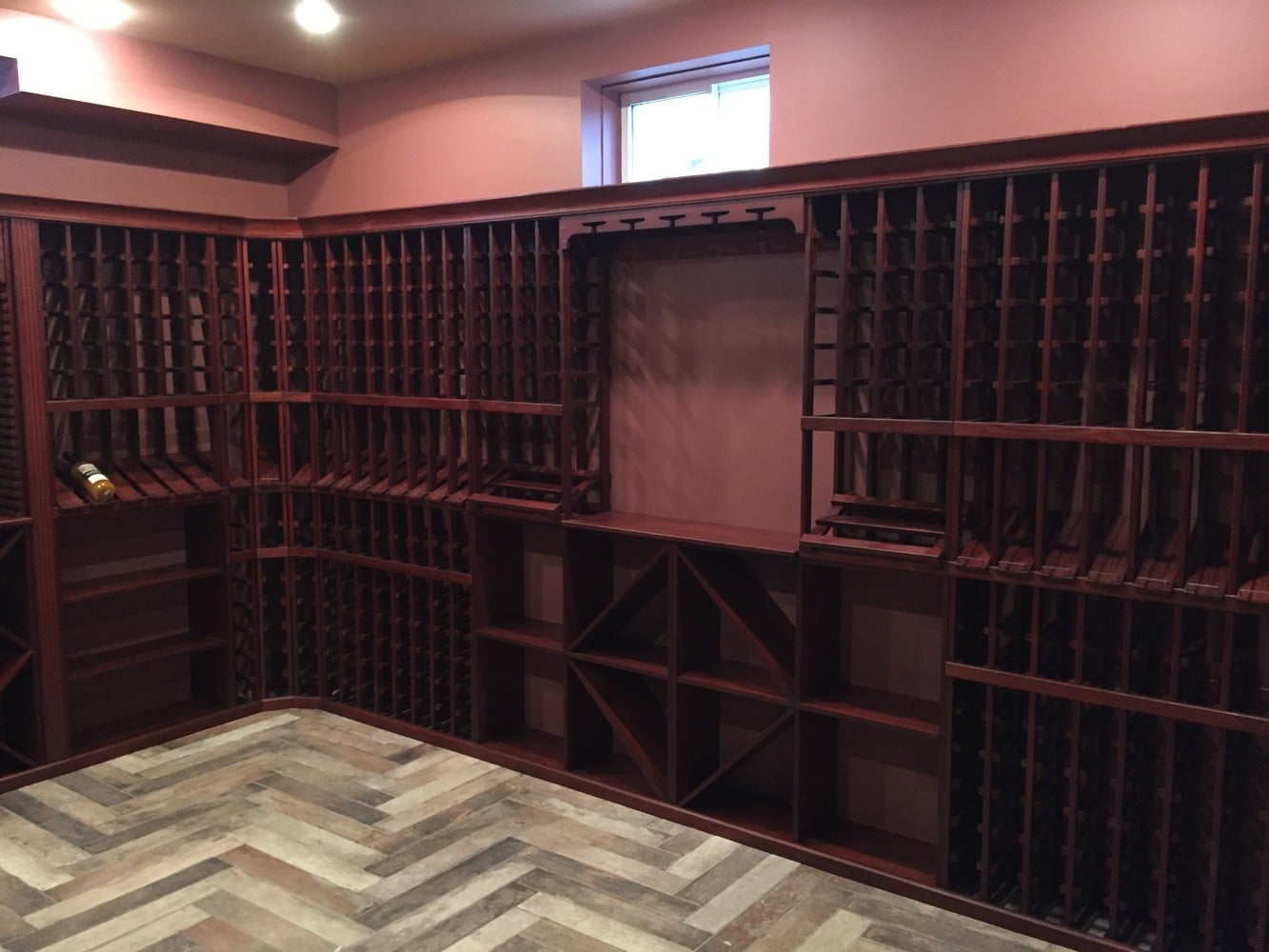 detailed wood wine rack installation in basement by BelPort Building & Remodeling in Chatham, MA