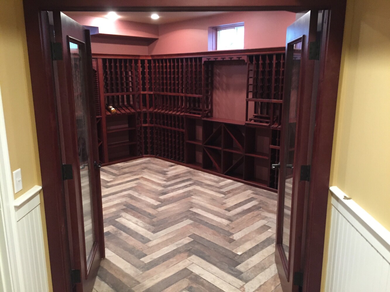 finished basement wine cellar entrance with double doors by BelPort Building & Remodeling in Chatham, MA
