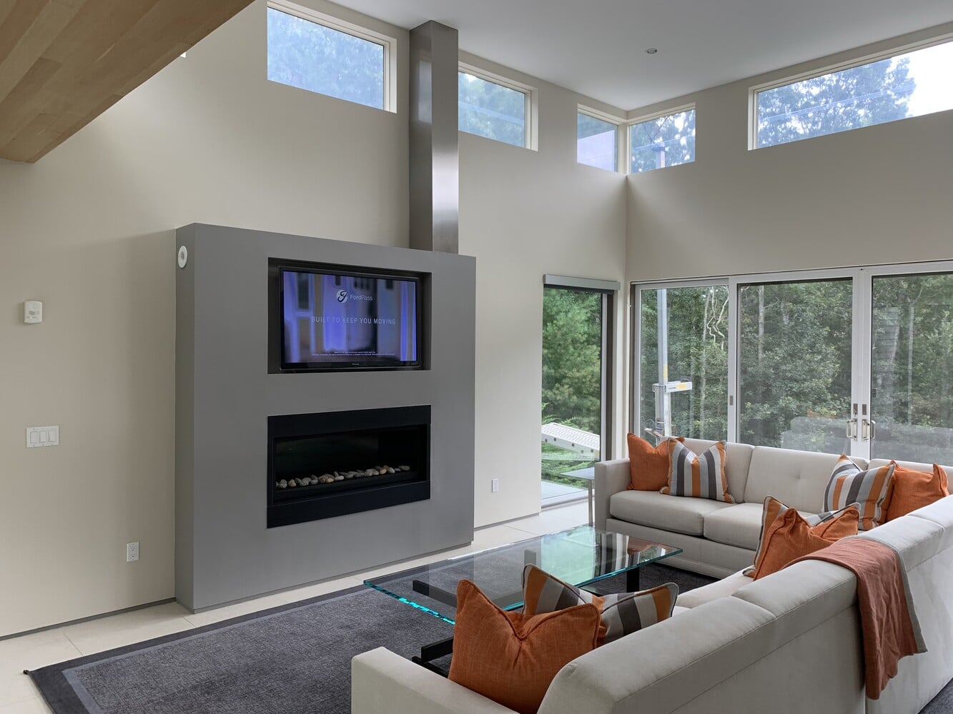 living room with fireplace and large windows in Mashpee MA custom home by BelPort Building & Remodeling
