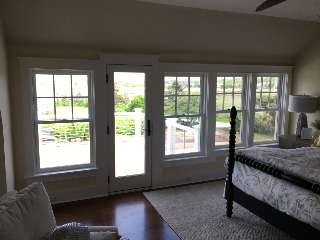remodeled coastal bedroom with large windows and deck door by BelPort Building & Remodeling in Barnstable MA